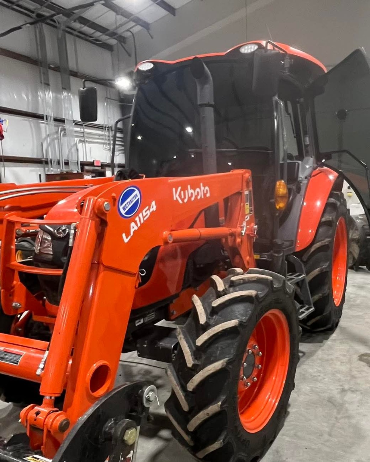 Orange Kubota tractor with tinted windows